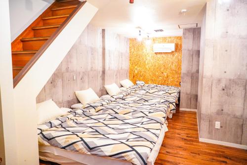 a large bed in a room with a staircase at ONE HOSTEL Himeji in Himeji