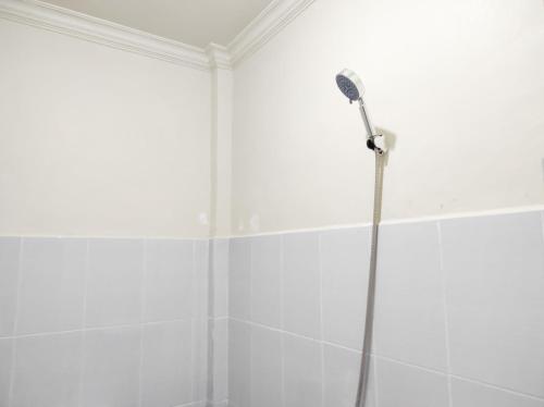 a shower in a white bathroom with at RedDoorz Syariah at Karema Area Mamuju in Karema