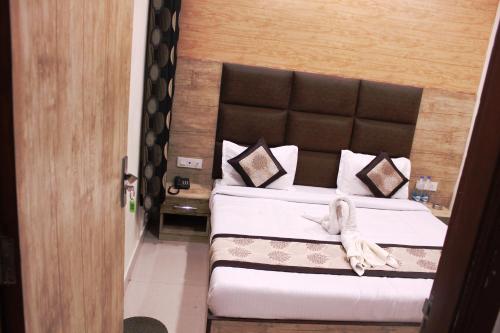 a bedroom with a large bed with a head board at Shree Krishna Hotels in Amritsar