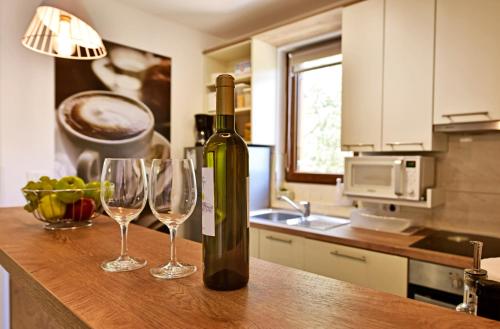 una botella de vino sentada en un mostrador con dos copas de vino en Apartment surrounded by a Vineyard, en Tar