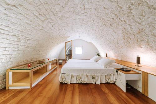 a bedroom with a bed and a brick wall at Santa Rosa Relais in Noci