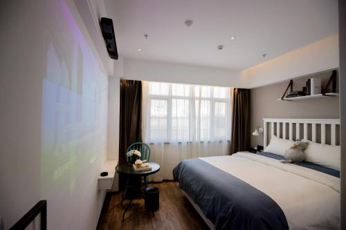 een slaapkamer met een groot bed en een raam bij 银座精宿酒店（济南莱芜旅发印象城凤城西大街店） in Laiwu