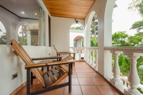 a porch with two rocking chairs on a house at Posada el Quijote in San José