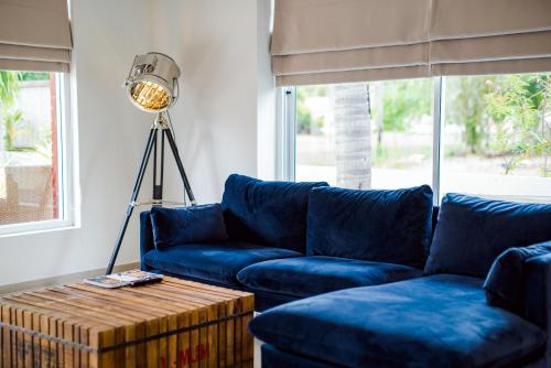uma sala de estar com um sofá azul e um candeeiro em The Beach Village Resort em Sam Roi Yot