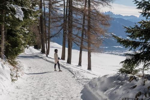 a person walking down a snow covered road at Hotel Milla Montis in Maranza