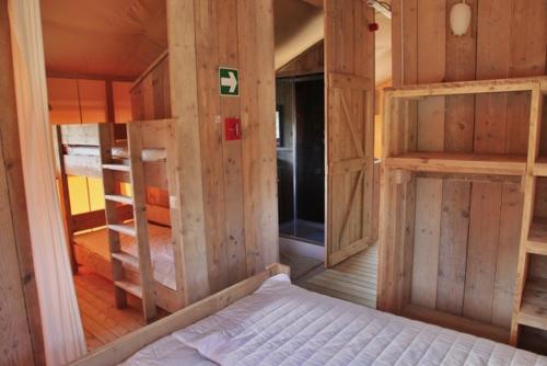 1 dormitorio con paredes de madera y 1 cama en una habitación en Ijsmolenhoeve, en Ronse