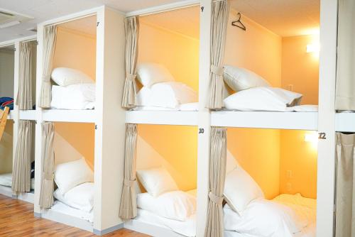 a room with white shelves with pillows at ONE HOSTEL Himeji ワンホステル姫路 in Himeji