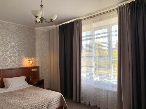 GeorgiyevskにあるHotel Koronaのベッドルーム1室(ベッド1台、大きな窓付)