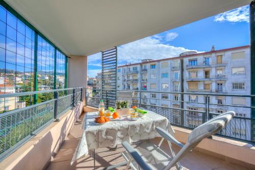 balcón con mesa y sillas y vistas a un edificio en Appartement Liberation - Happy Rentals, en Niza