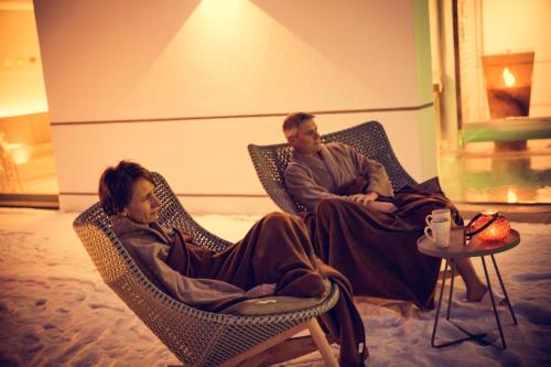 a man and a woman sitting in wicker chairs at Hotel St. Florian in Frauenau