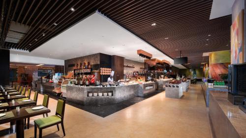 a restaurant with a bar with tables and chairs at Holiday Inn Nanchang Riverside by IHG in Nanchang