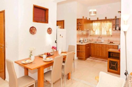 cocina y comedor con mesa de madera y sillas en TETRAKTYS estate, en Ágios Matthaíos