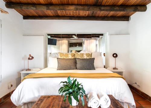 Hermanus的住宿－Hemel 'N Aarde Stud，一间卧室设有一张带木制天花板的大床