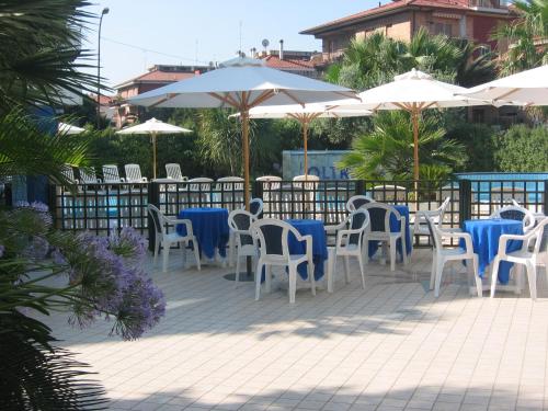 a patio with tables and chairs and umbrellas at Residence Oltremare in San Benedetto del Tronto