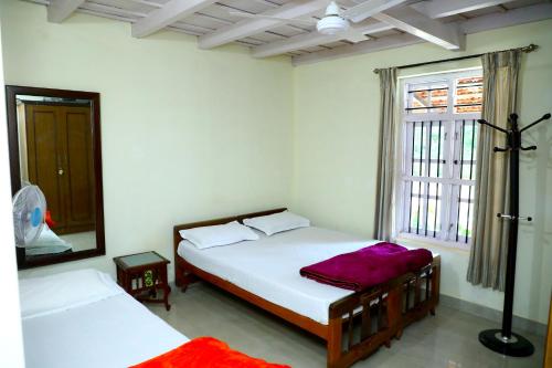 una camera da letto con due letti e una finestra di GREEN INN a Sakleshpur
