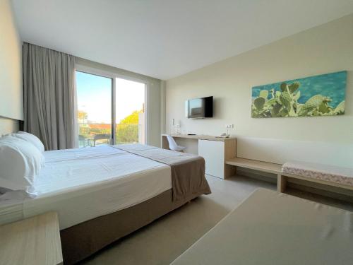a hotel room with a bed and a window at Garbi Cala Millor in Cala Millor
