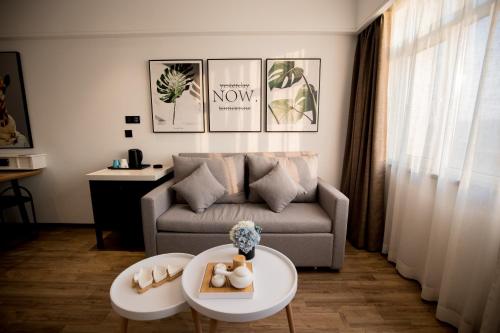 een woonkamer met een bank en een tafel bij 银座精宿酒店（济南莱芜旅发印象城凤城西大街店） in Laiwu