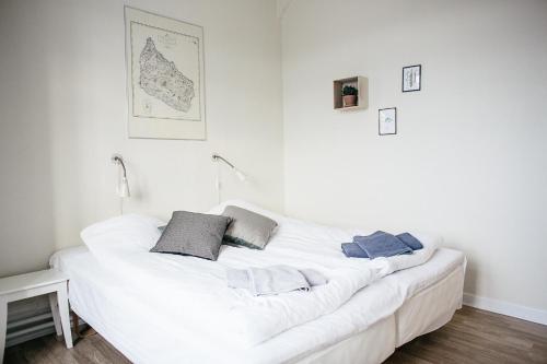 a white bed with two pillows on it in a room at Langebjerg Pension & Spisested in Allinge
