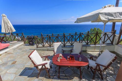 a patio with a table and chairs and the ocean at St John's Agios Ioannis Pelion in Agios Ioannis Pelio