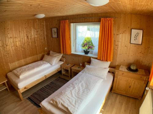 two beds in a room with a window at Zimmervermietung Ziegltrum in Wolfersdorf