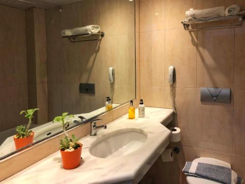 a bathroom with a sink and a mirror at Caravel Hotel Apartments in Ixia