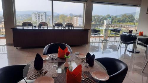 comedor con mesa y sillas con vistas en Hotel Livbox, en Dehradun