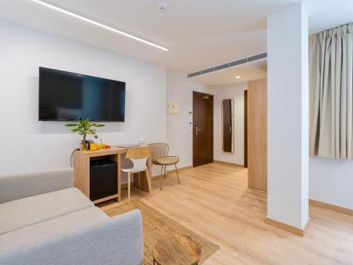 a living room with a bed and a desk with a tv at Hotel Emeté & Coworking by Airnest in Las Palmas de Gran Canaria