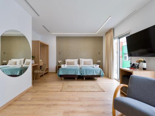 a bedroom with a bed and a tv and a couch at Hotel Emeté & Coworking by Airnest in Las Palmas de Gran Canaria