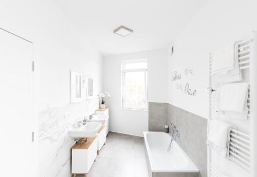 een witte badkamer met 2 wastafels en spiegels bij Moderne 2 Zimmer Ferienwohnung mit Dachterrasse - 95qm in Bremerhaven