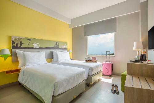 a hotel room with two beds and a window at KHAS Surabaya in Surabaya