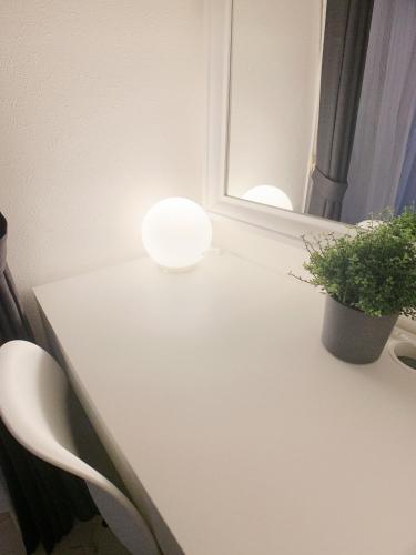 a white table with a potted plant and a mirror at OUCHI HOTEL Fujimi in Hiroshima