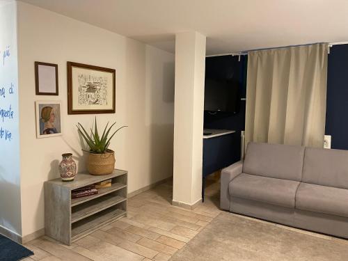 ein Wohnzimmer mit einem Sofa und einem Tisch in der Unterkunft Splendida taverna dotata di tutti i comfort a 500 mt dal mare in Marina di Carrara