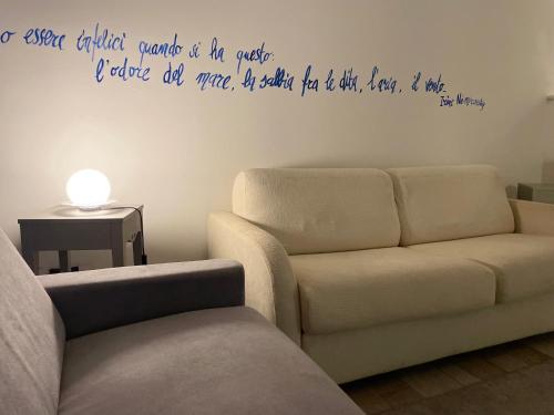 ein Wohnzimmer mit einem Sofa, einem Sofa und einer Wand in der Unterkunft Splendida taverna dotata di tutti i comfort a 500 mt dal mare in Marina di Carrara
