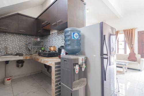 a kitchen with a stainless steel refrigerator and a counter at Small Homestay Syariah Sikembar Ciwidey Mitra RedDoorz in Bandung
