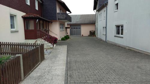un callejón entre dos edificios con una valla en Ferienhaus Pauline en Sandberg