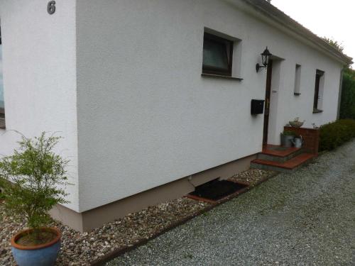 a side of a white house with the door open at FeWo Ostseestrand in Neustadt in Holstein