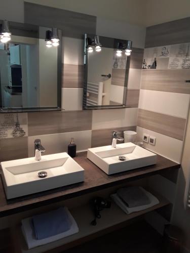 La salle de bains est pourvue de 2 lavabos et d'un grand miroir. dans l'établissement Studio du sentier des ocres, à Roussillon