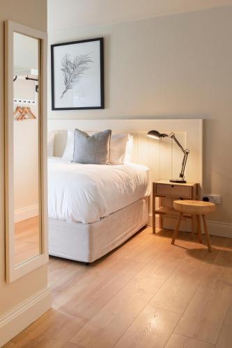 a bedroom with a bed and a table with a lamp at Lagom Restaurant & Townhouse in Kenmare