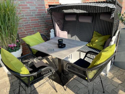 a table and four chairs on a patio at Hotel am Feldmarksee in Sassenberg