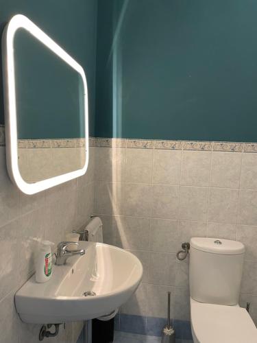 uma casa de banho com um lavatório, um WC e um espelho. em Spaziosa camera con letto alla francese e balcone a 500 mt dal mare em Marina di Carrara