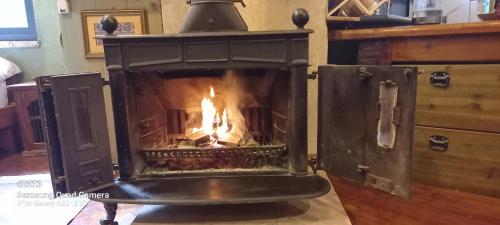 a fireplace with a fire in it in a room at קטלב kta-love in Kammon