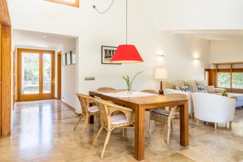 a dining room with a table and chairs and a couch at Villa Cal Padri By SunVillas Mallorca in Pollença