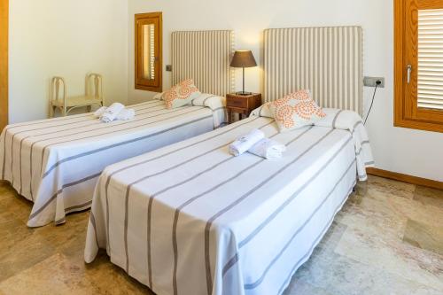 two beds in a hotel room with at Villa Cal Padri By SunVillas Mallorca in Pollença