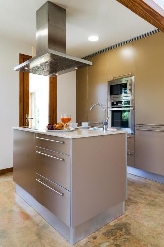 a large kitchen with a sink and a stove at Villa Cal Padri By SunVillas Mallorca in Pollença