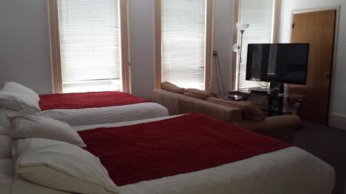 a hotel room with two beds and a television at Sage Motel in Vernal