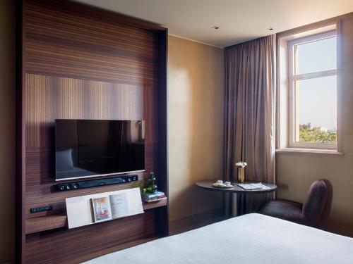 a hotel room with a bed and a television at ME Milan Il Duca in Milan