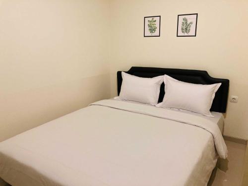 SeturanHartono Inn Seturan Mitra RedDoorz的卧室配有白色的床和2个枕头