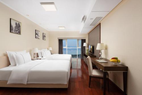 a hotel room with a bed and a desk and a bed and a desk at Shenzhen Bay Hisoar Hotel in Shenzhen
