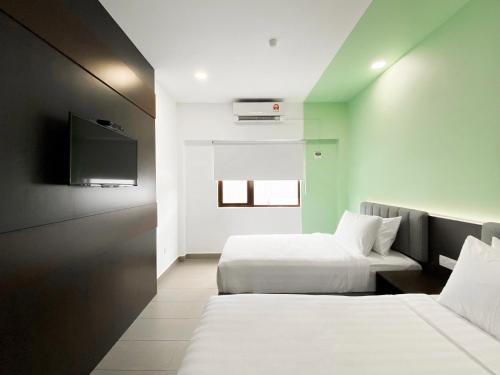 a hotel room with two beds and a flat screen tv at The Concept Hotel Langkawi in Kuah