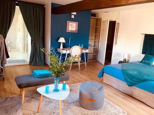 Manoir de la Gravette Maison d'Hôtes في مونتوبان: غرفة نوم زرقاء مع سرير وطاولة